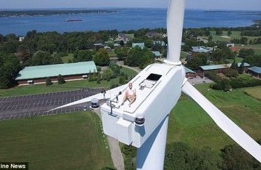 Un piloto de drones capta a un hombre tomando el sol en un molino eólico